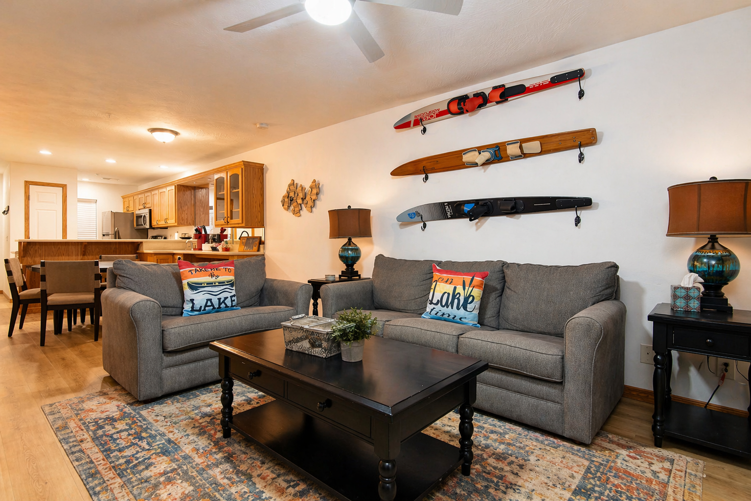 Living room with two gray sofas, ski decor, and open kitchen behind